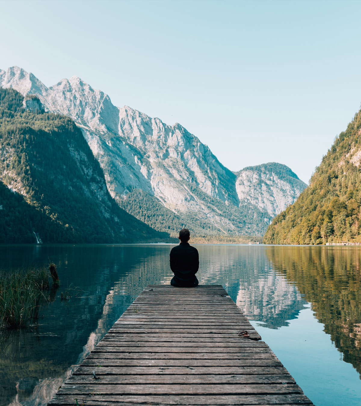photo of a person sitting at the end of a pier after Humanistic Therapy