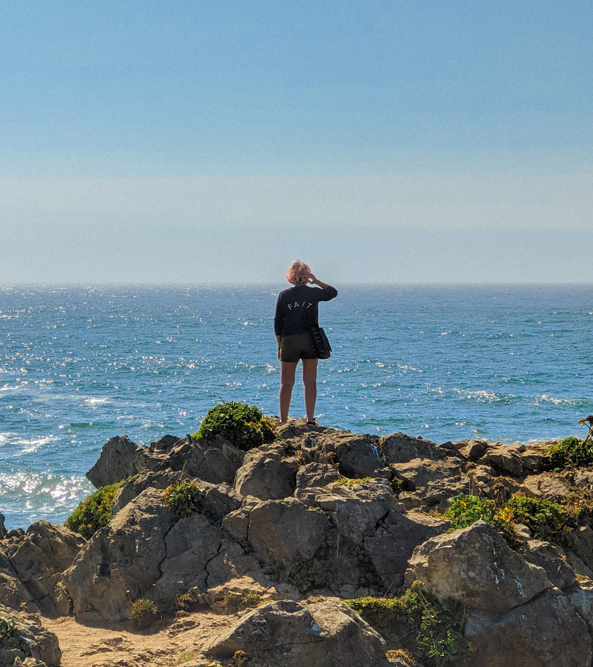photo of a woman at the coast looking out to the ocean thinking about Existentialism