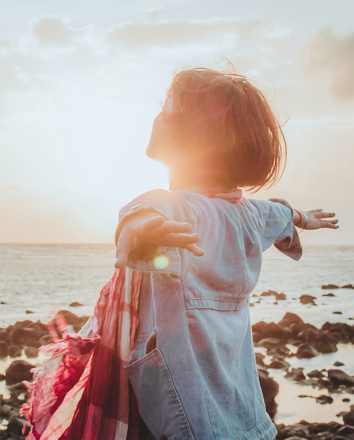 photo of a person spreading their arms at the beach after an individual therapy session