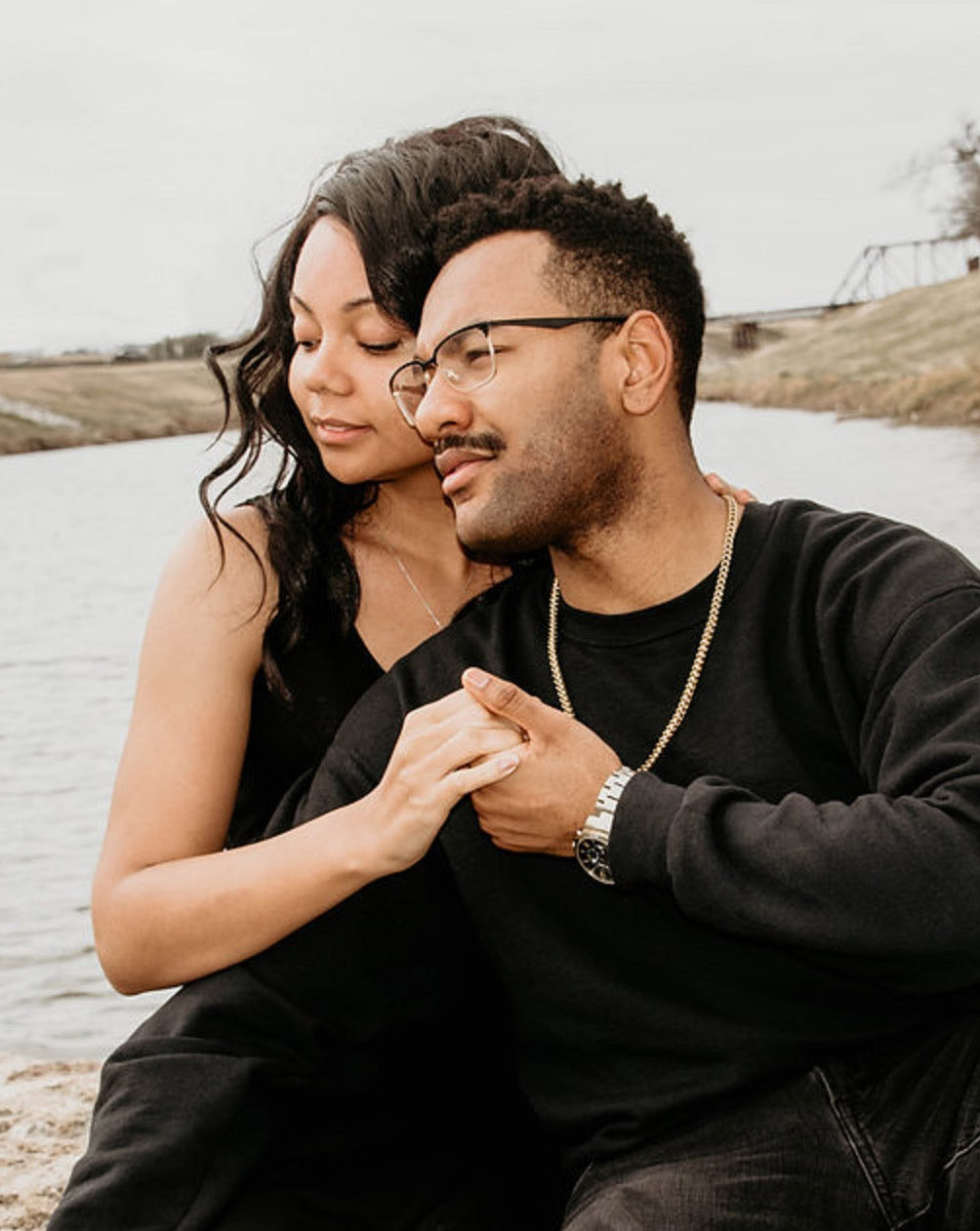 photo of a man and woman holding hands next to a river after couples therapy