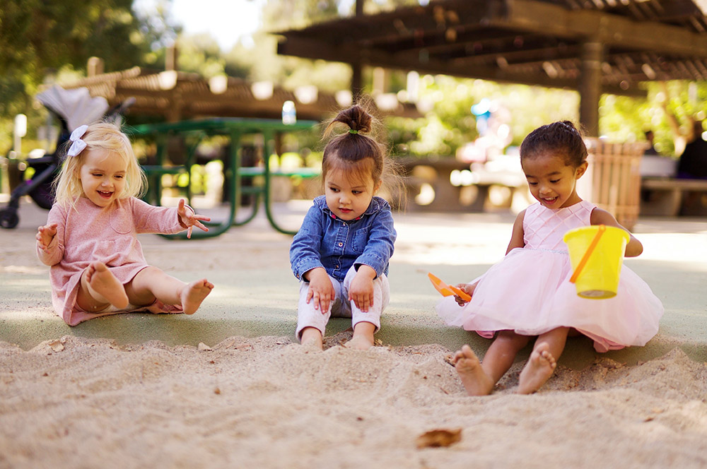 photo of children playing in a sandbox as part of sandplay therapy